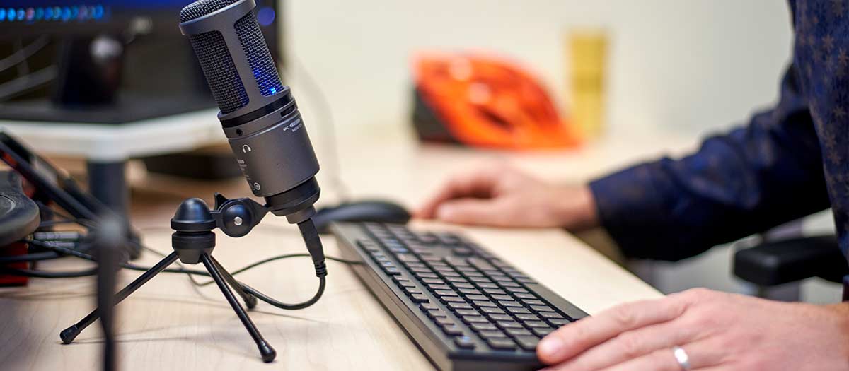 Close-up view of Jaap Vos's hands at his keyboard with a microphone just in front of the keyboard.