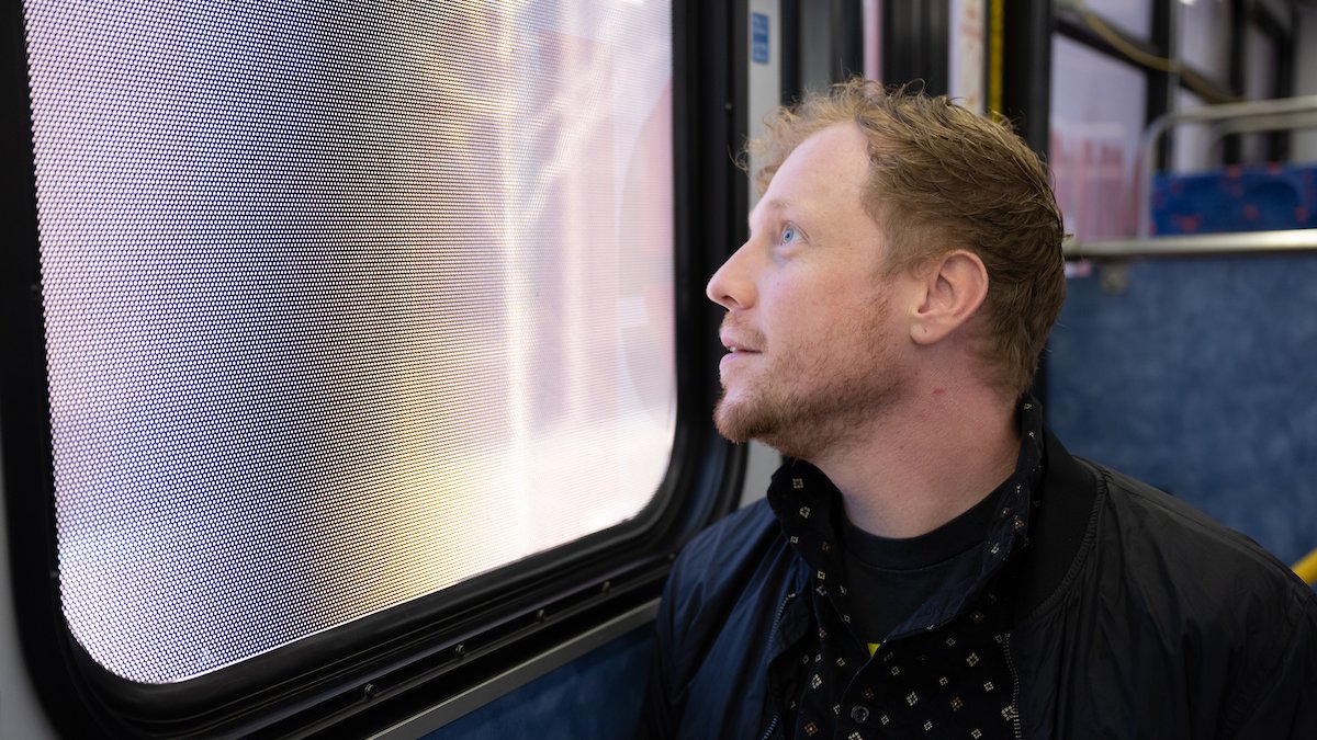 Tyler Schram looks out the window of a bus. 