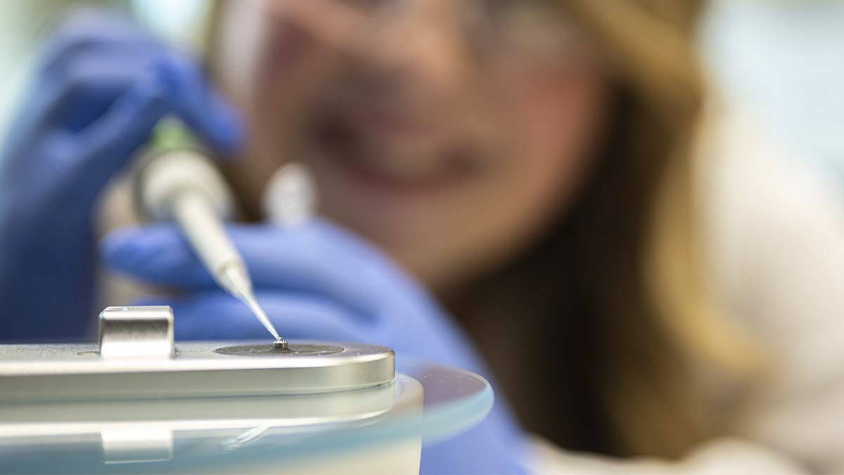 Close up of pipette with a drop of liquid.