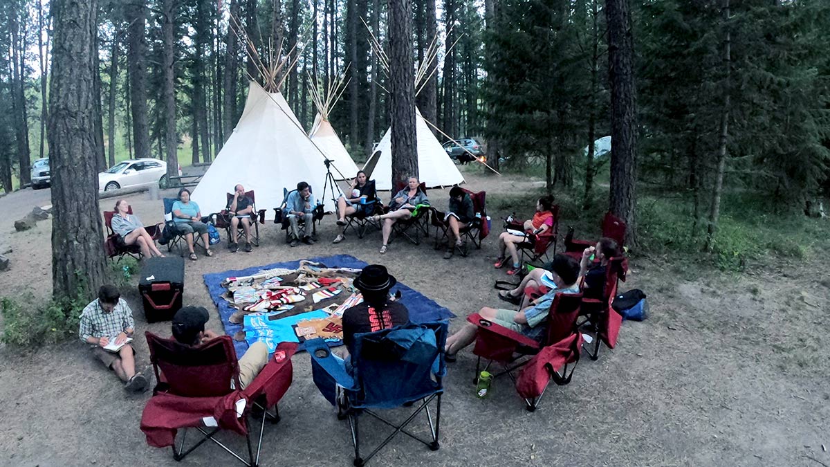 group sitting in circle in camp