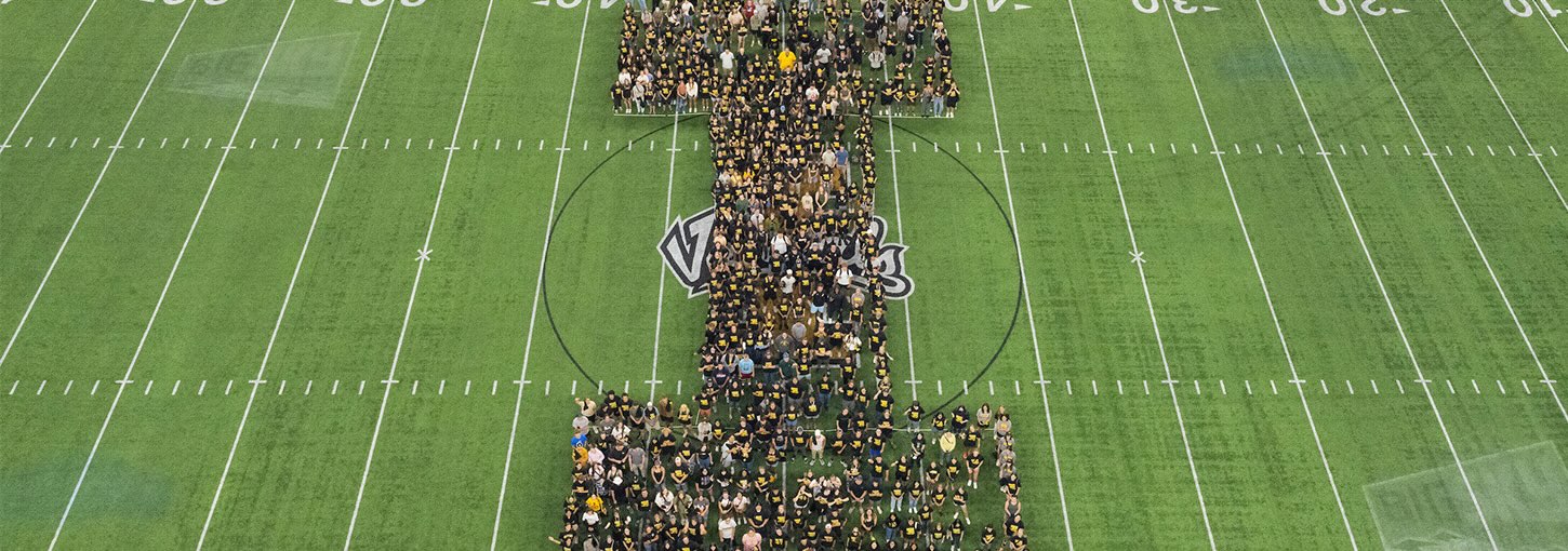 U of I freshman class standing in an "I" formation on the football field