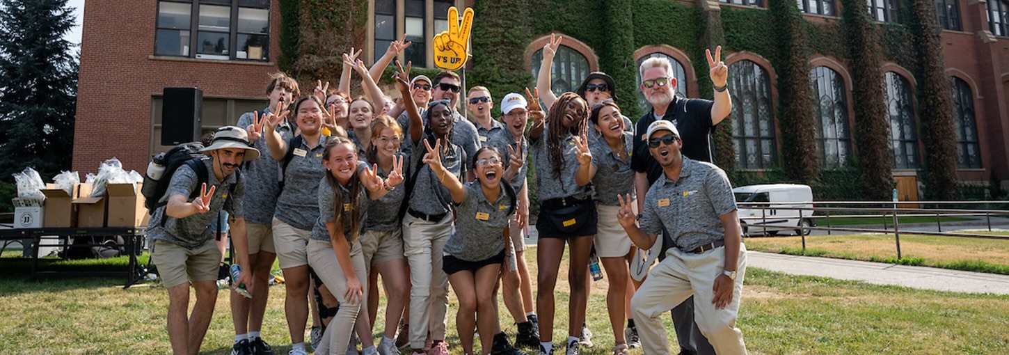 A group of students and faculty members standing in front of a U of I building