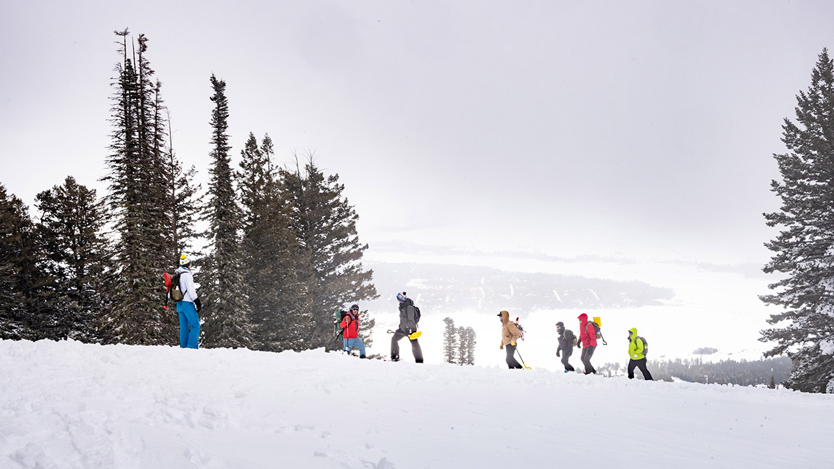 A group of skiers on top of a snowy mountain