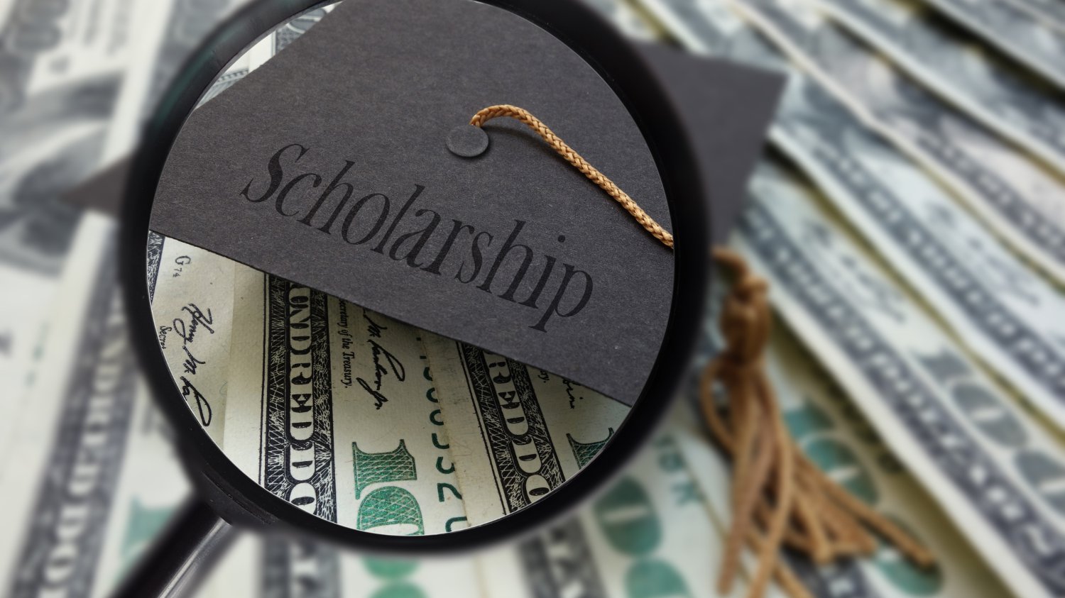 Stach of US currency and a cap that reads "scholarships".