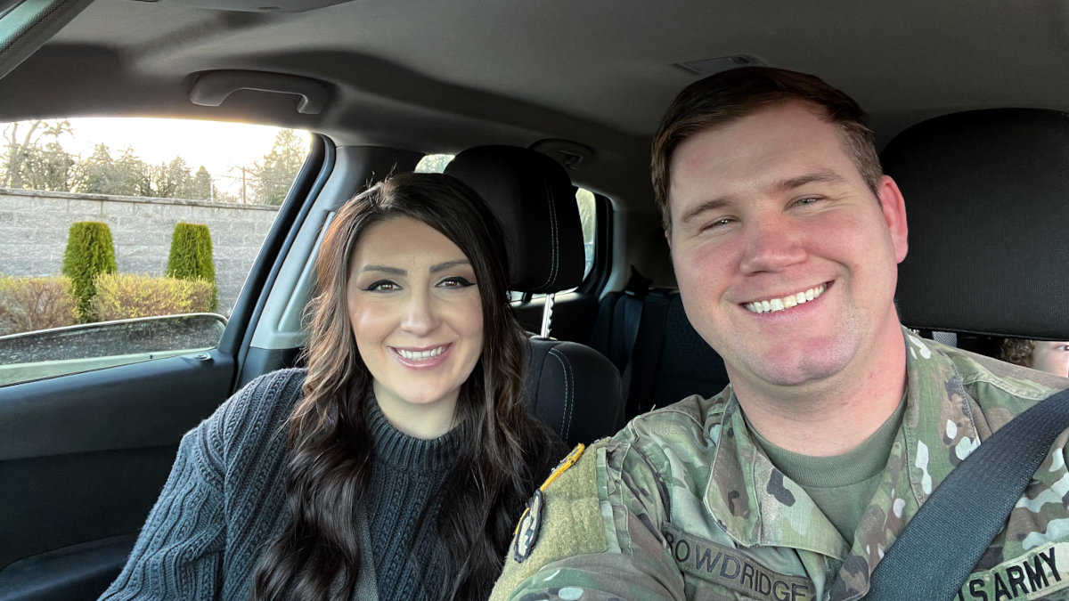 Smiling couple in front seat of car.