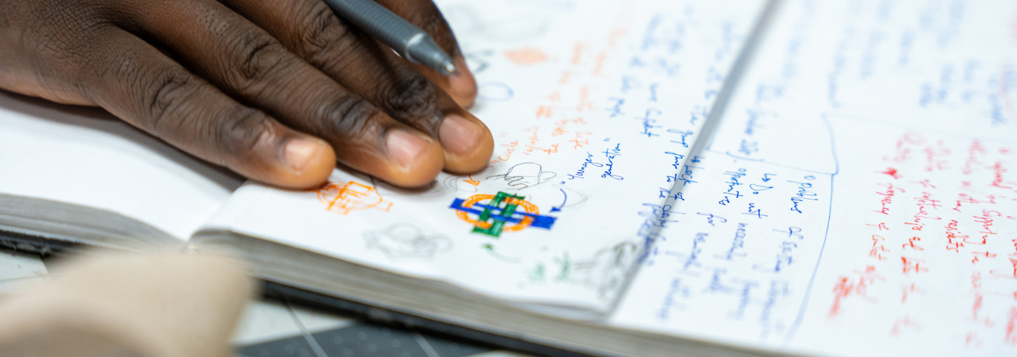 Closeup of hand holding pen on a notebook.