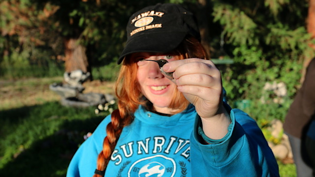 Woman holds a hummingbird.