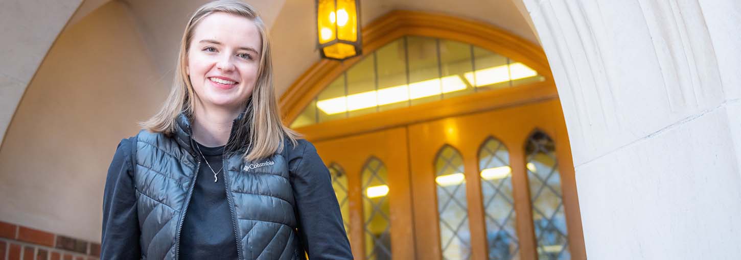 Grace Meyer stands in front of a door