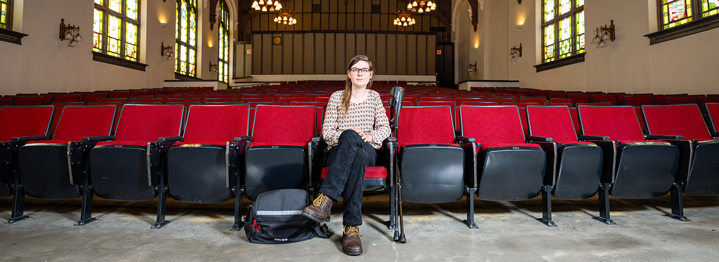 Woman sitting in empty theater.