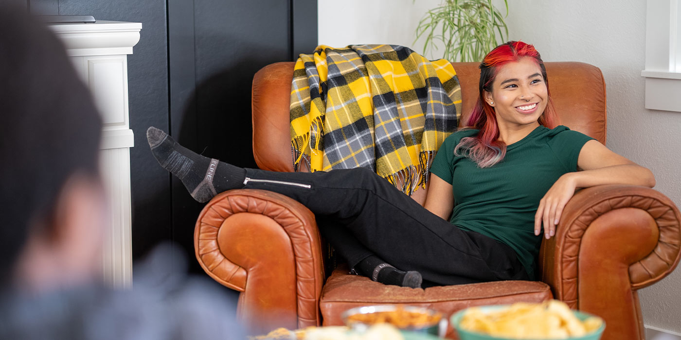 A portrait of Esther lounging in a large leather chair